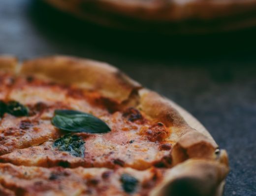 selective focus photography of two pizzas