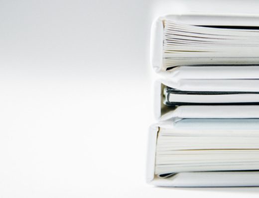 A stack of thick folders on a white surface